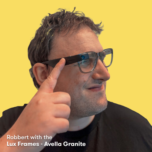 Robbert wearing the Envision Glasses with the Lux Frames - Avella Granite while having his fingers on the touchpad