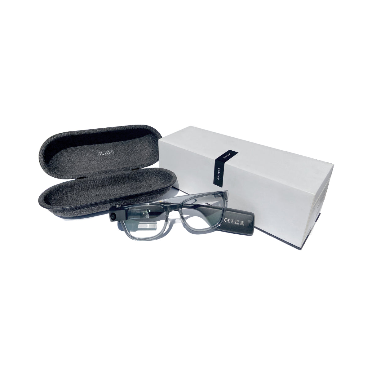 Folded in transparent grey frames attached to the Envision Glasses, laying next to the dark grey case and the white packaging it comes with.
