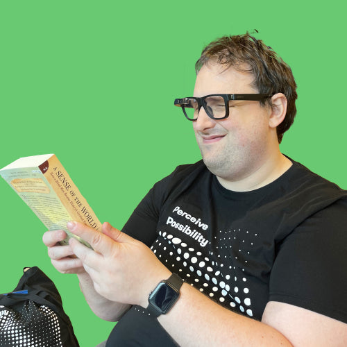 Robbert wearing the Envision Glasses with Designer Frame - Smith Optics while holding a book
